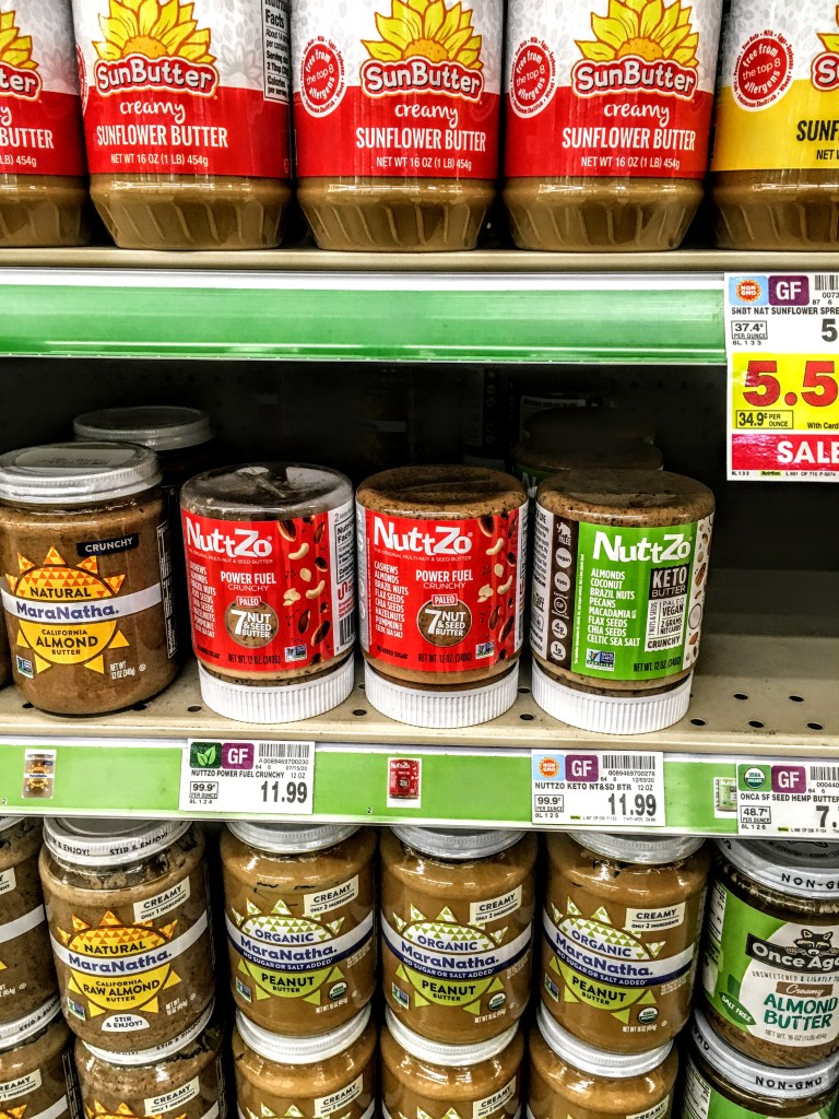 A store shelf displaying peanut butters, including Nutzzo Keto Butter. 