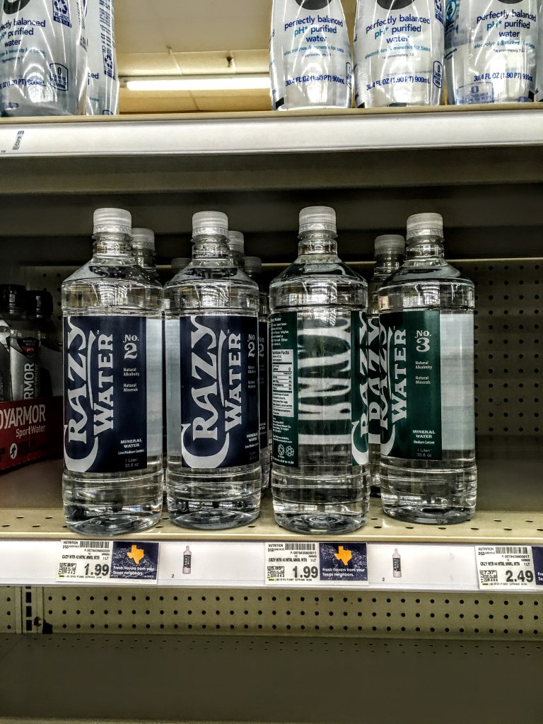 Bottles of Crazy Water stacked on store shelf