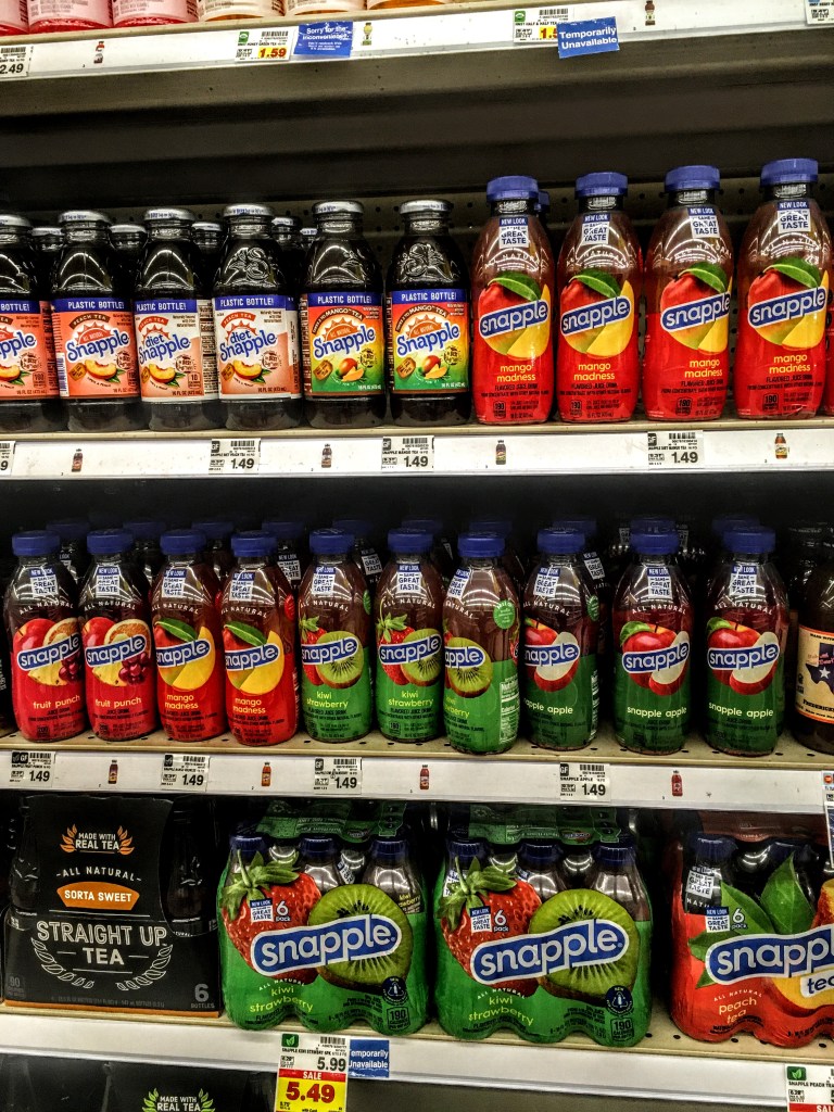 A store shelf displaying bottles of Snapple Mango Madness. 