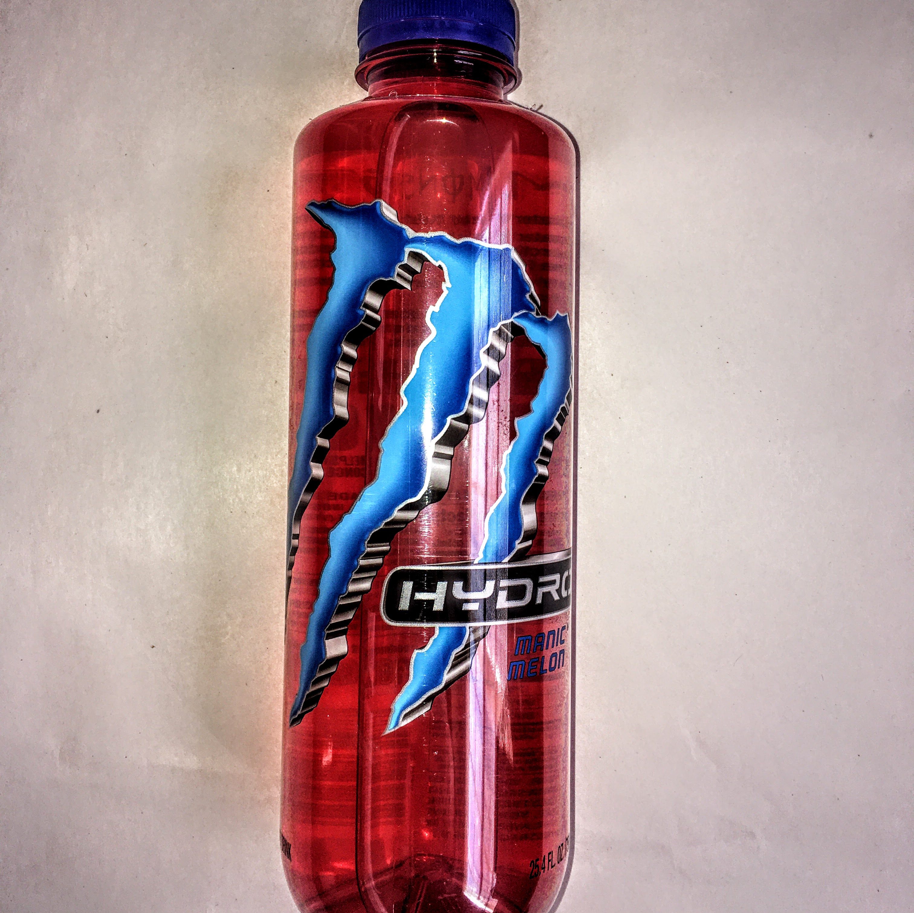 A bottle of Manic Mellon Monster Energy Drink. 